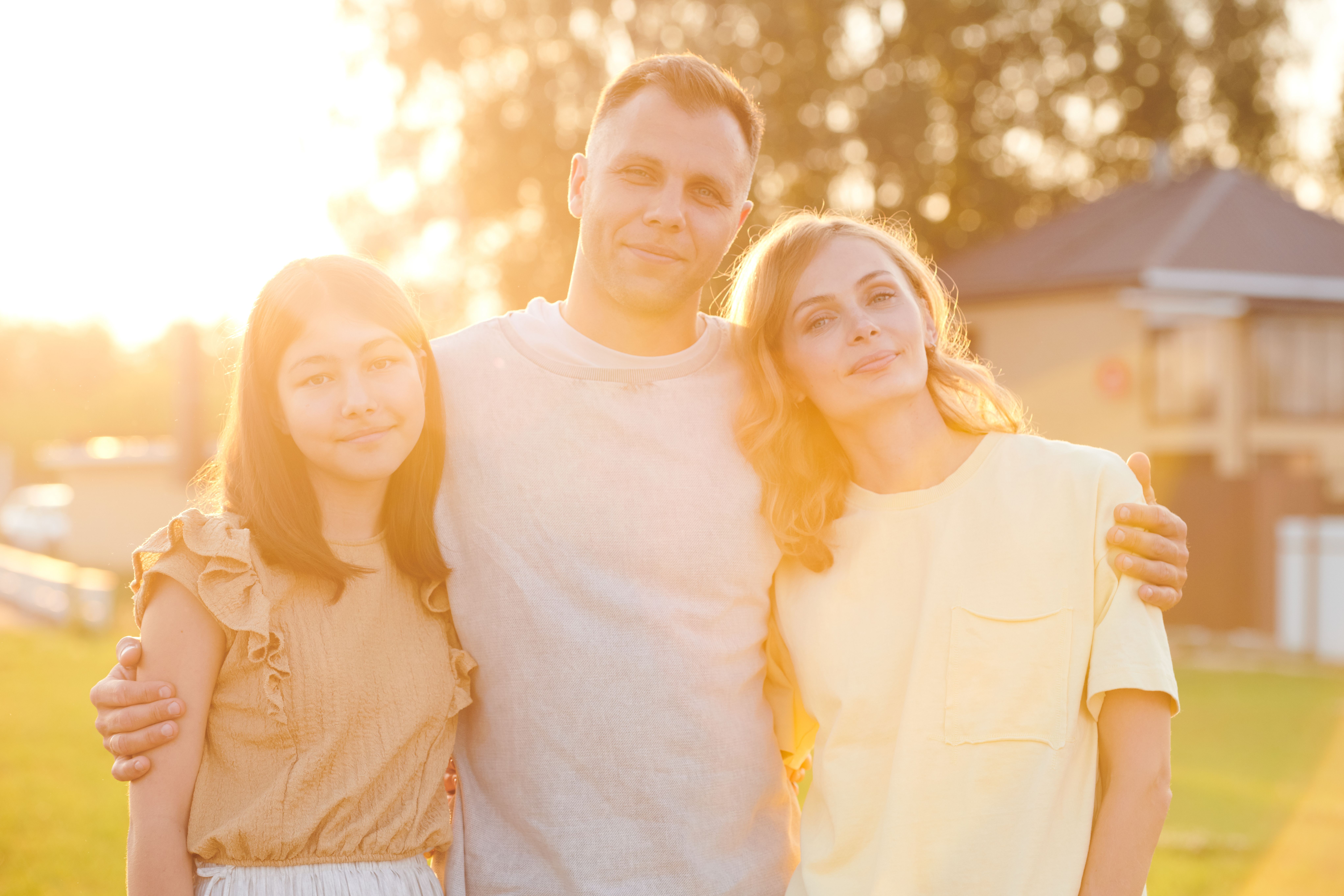 Parents and teenager posing for a picture outside together in a New Jersey neighborhood.